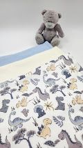 Soft baby blankets with dinosaur print alongside a plush teddy bear, perfect for nursery decor.