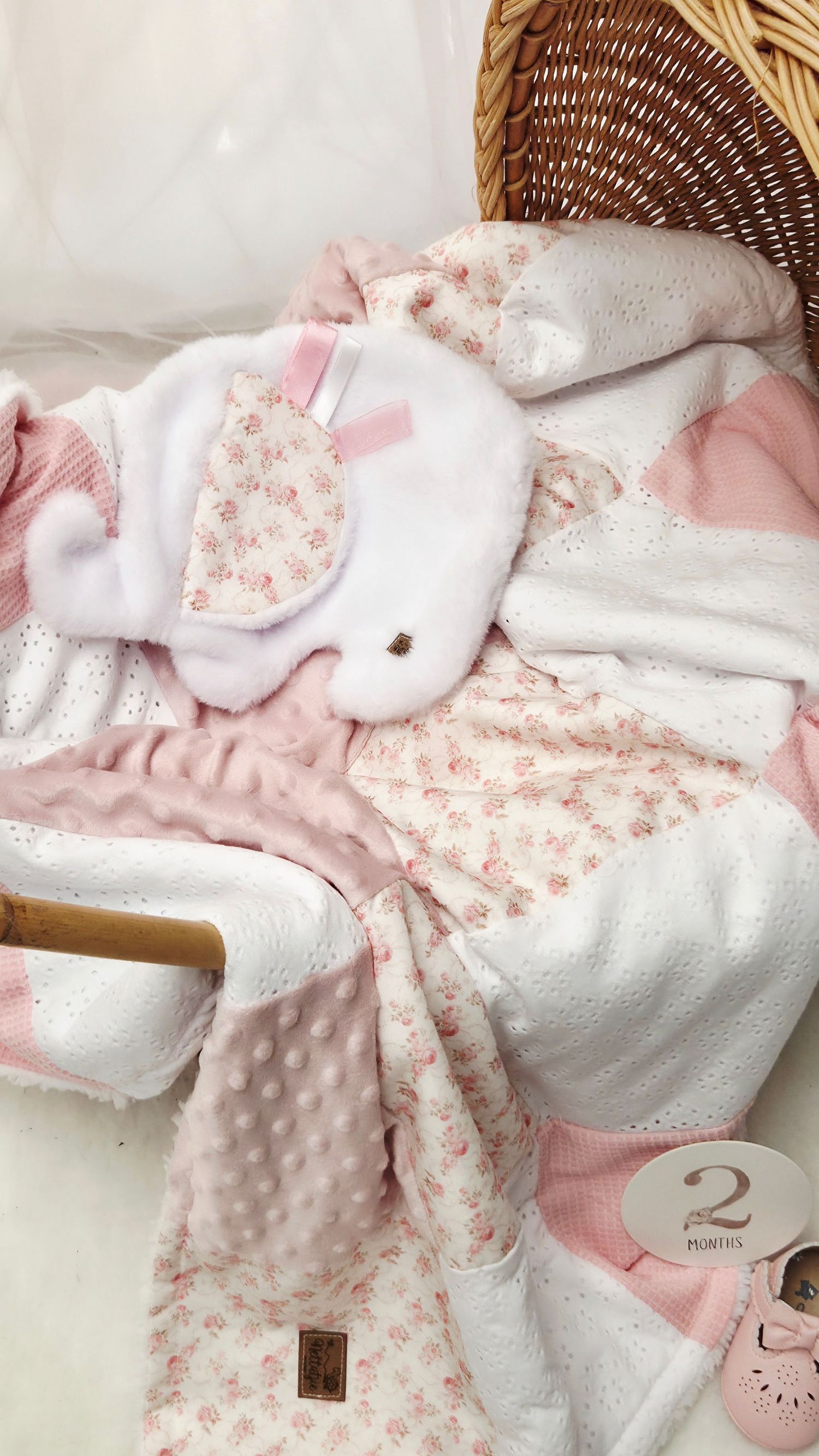 Pink floral baby blanket set with bunny lovey and 2 months milestone card on white background.