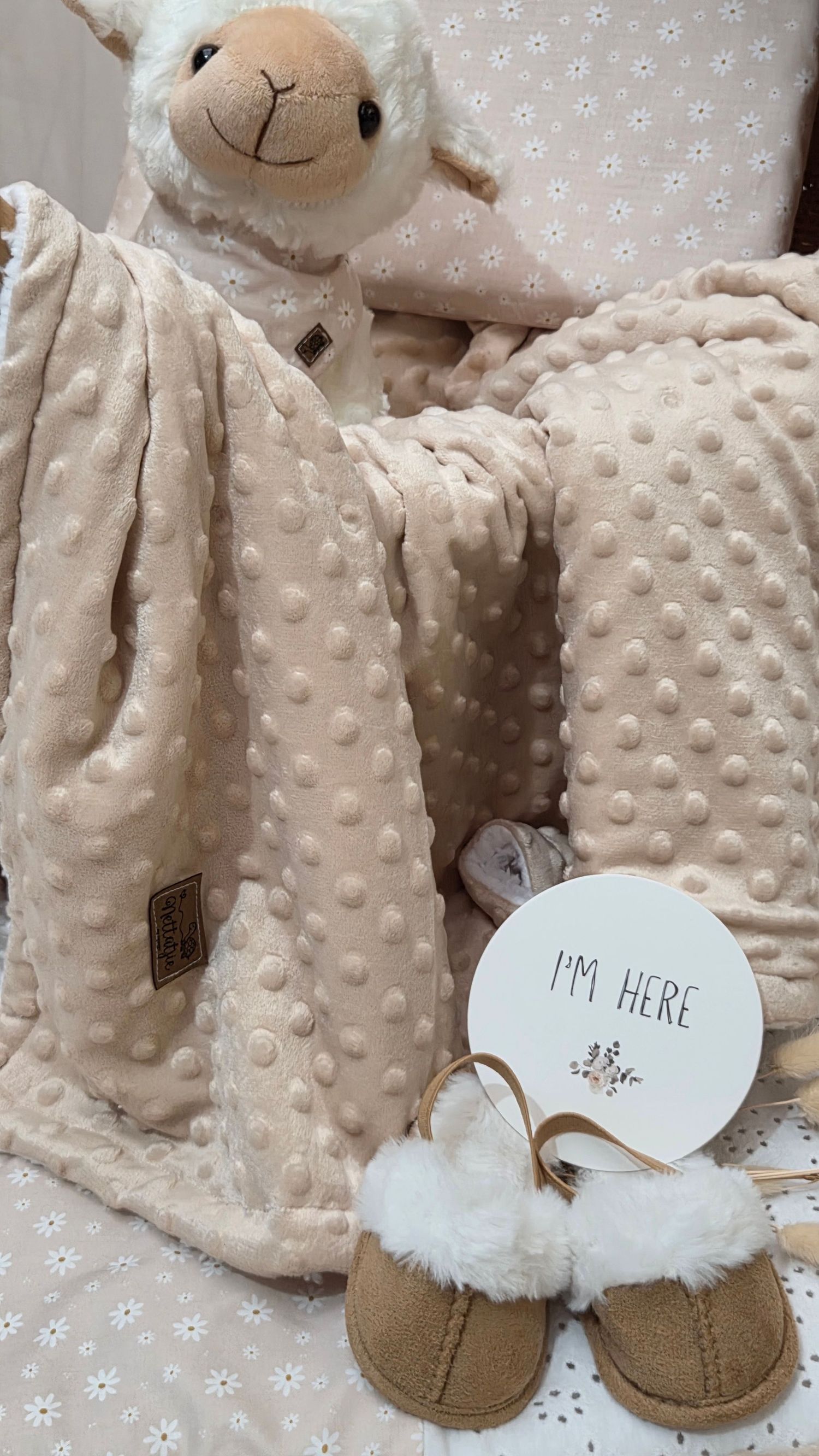 Neutral baby gift set with lamb plush, bubble blanket, fur slippers, and I'm Here sign.