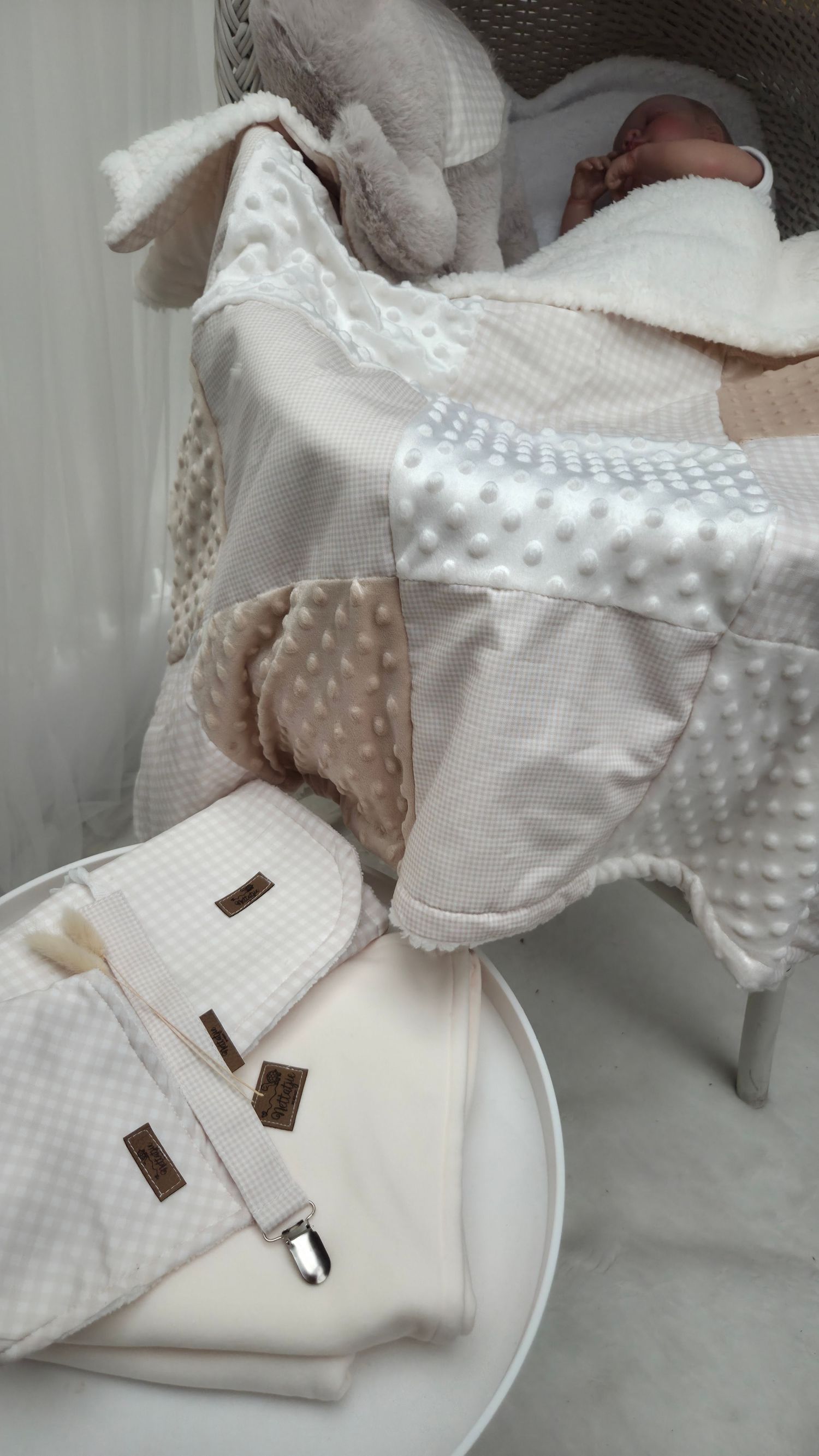 Soft neutral baby blanket set with minky dots and waffle fabric, displayed with a sleeping newborn in a white chair.