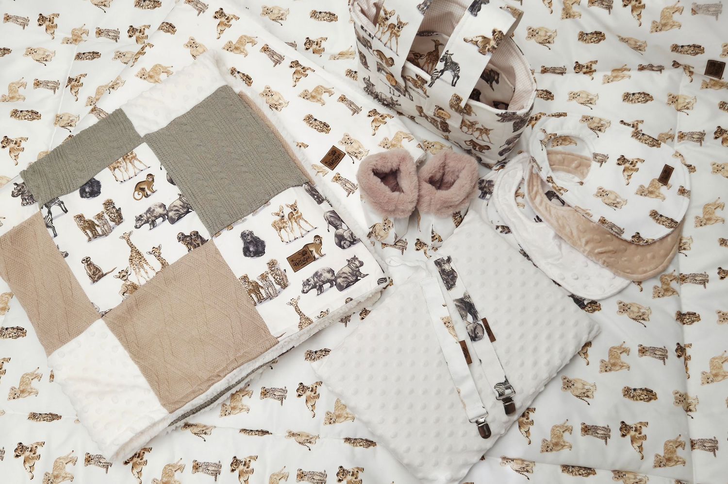Neutral-toned baby nursery set with woodland animal quilt, minky blanket, and matching fabric accessories.
