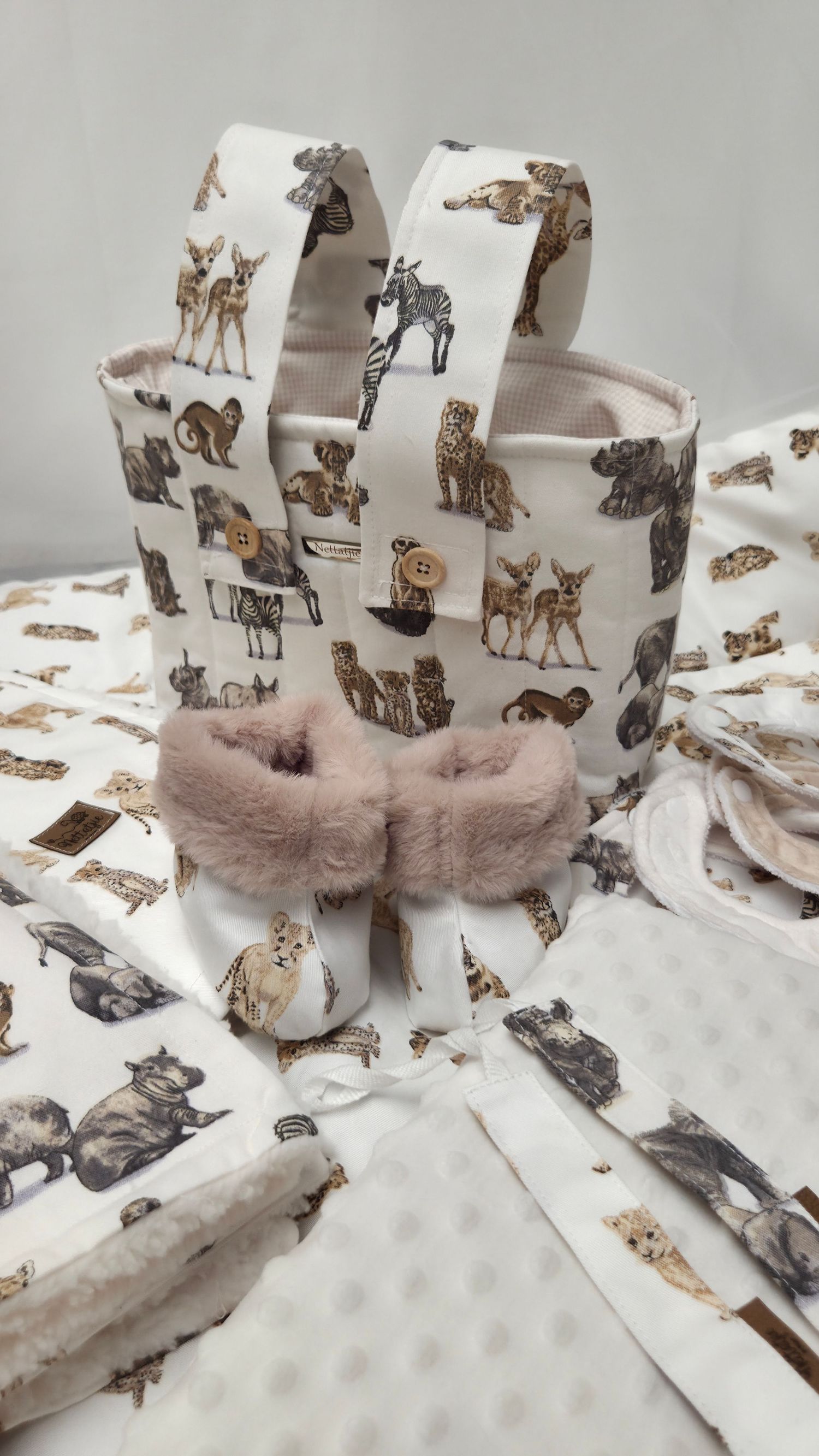 White fabric storage basket with safari animal print and pink faux fur bow, displayed with matching minky fabric swatches.