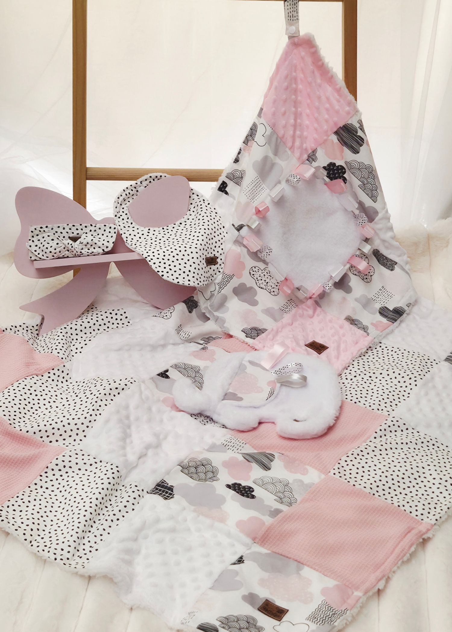 Pink and white baby gift set with patchwork quilt, teepee toy, stuffed bear, and cloud pillow.