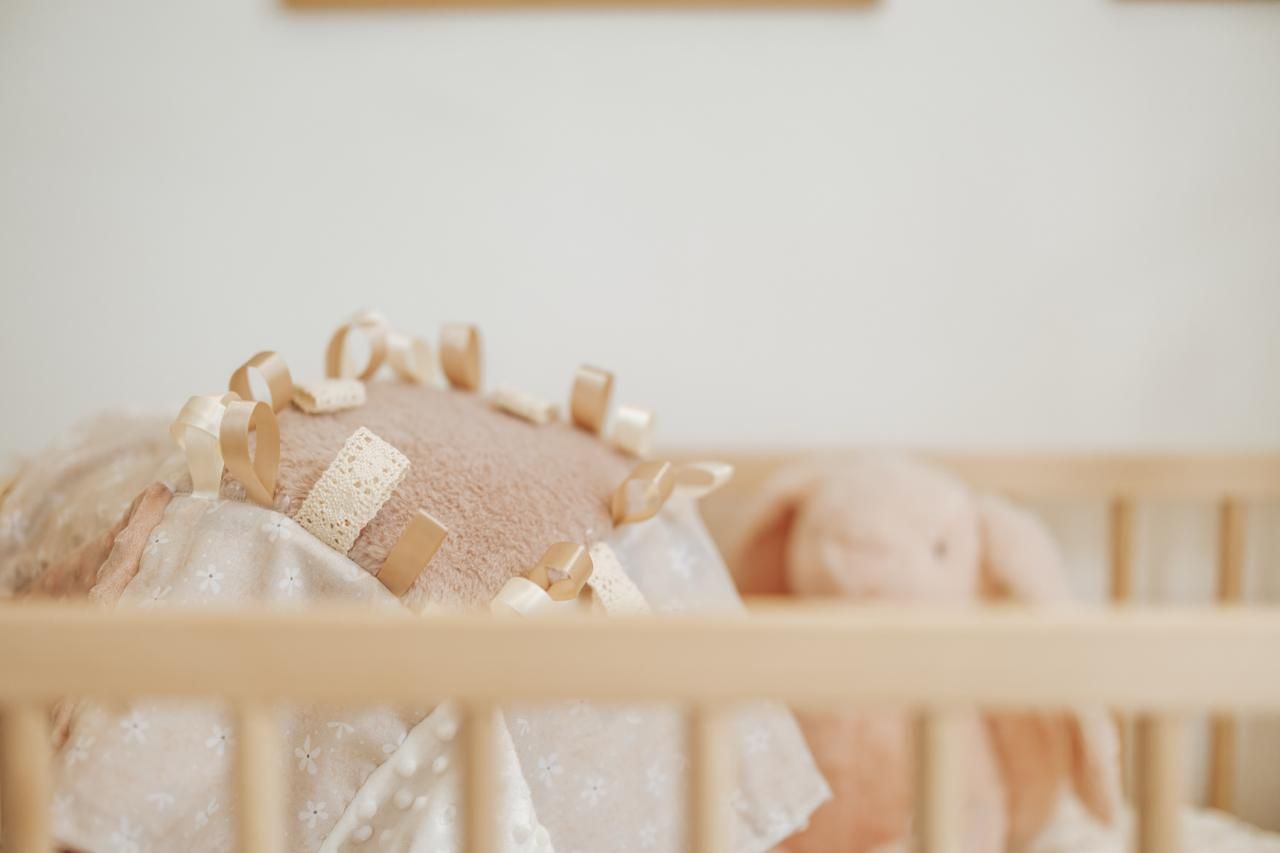 A collection of handcrafted wooden toys and natural objects arranged in a soft, neutral-toned display.
