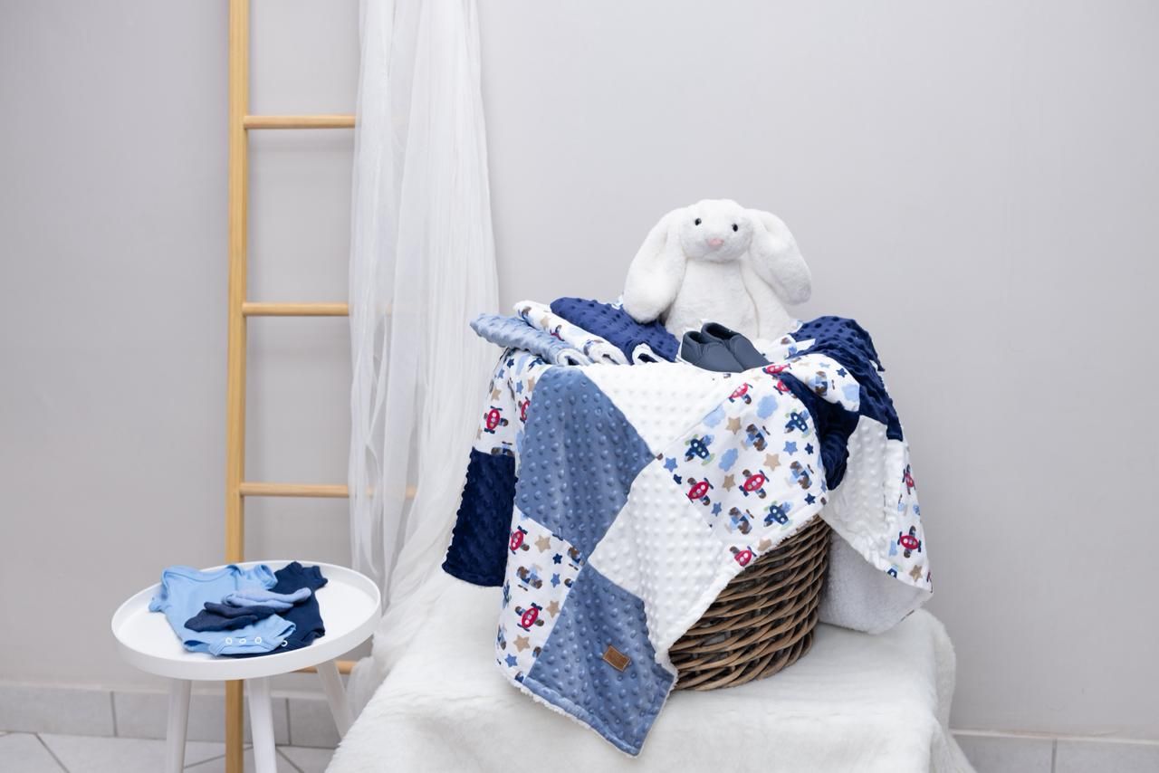 A white and blue baby nursery decor collection featuring a crib, bedding, blankets and coordinating accessories.