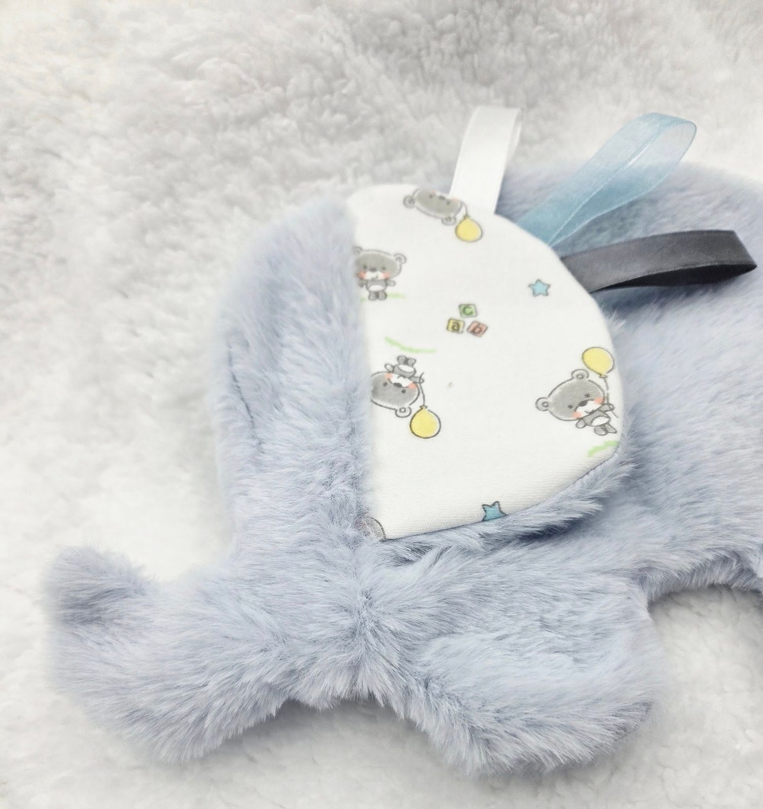 Cozy light blue plush baby blanket with white floral pattern and matching accessories.