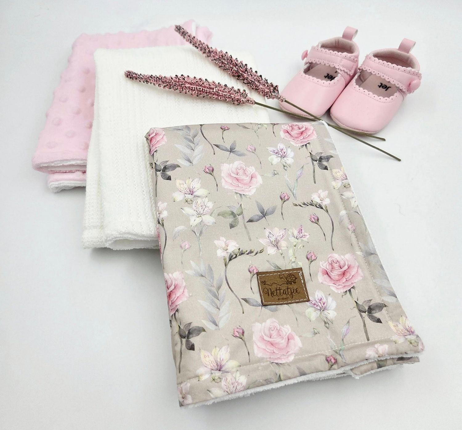 Pink floral baby blanket with delicate rose pattern shown from multiple angles.