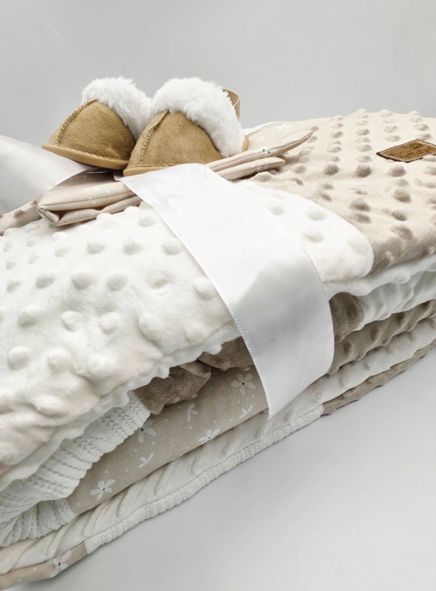 Plush white minky blanket with textured dots and neutral trim.