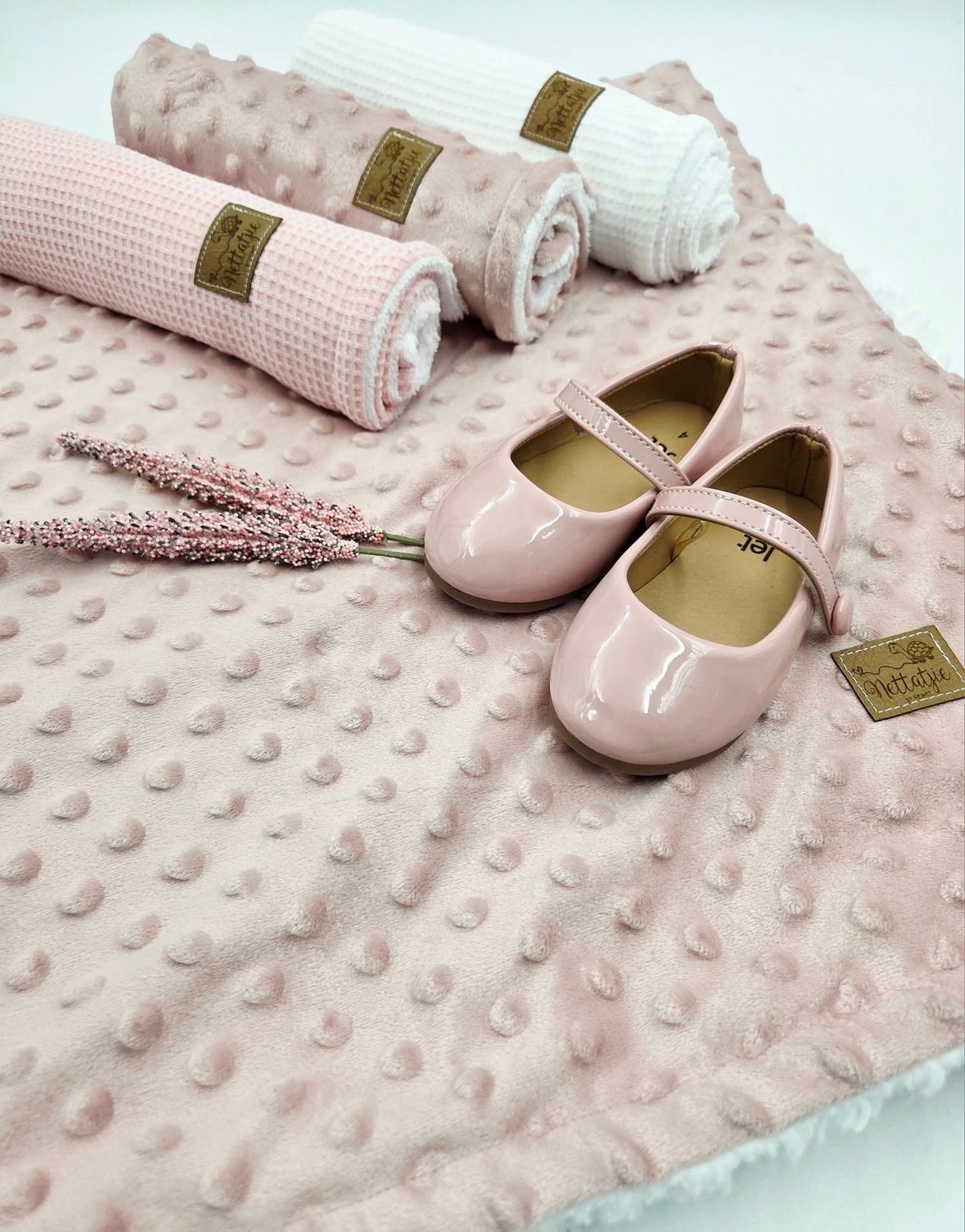 Pink textured minky blanket with matching ballet flats and white trim displayed on white background.