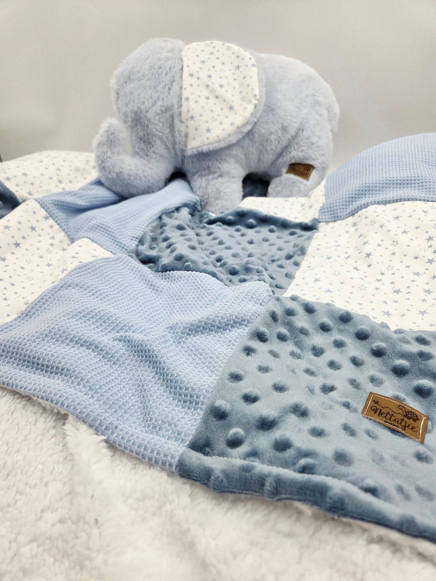 Soft blue minky baby blanket with dotted texture and white eyelet fabric detail.