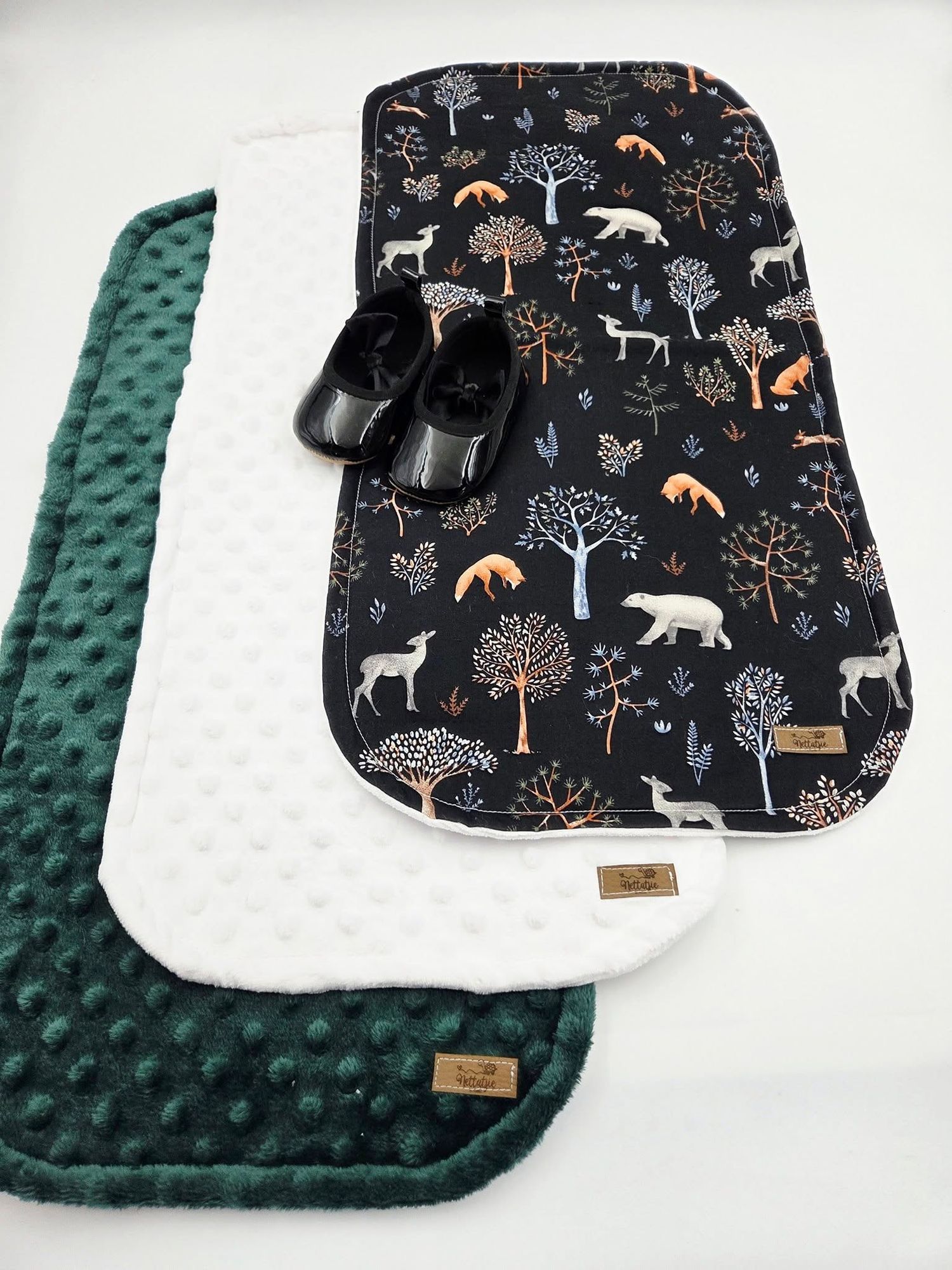 Forest animal print baby blanket with green minky backing features woodland creatures and trees on black background.