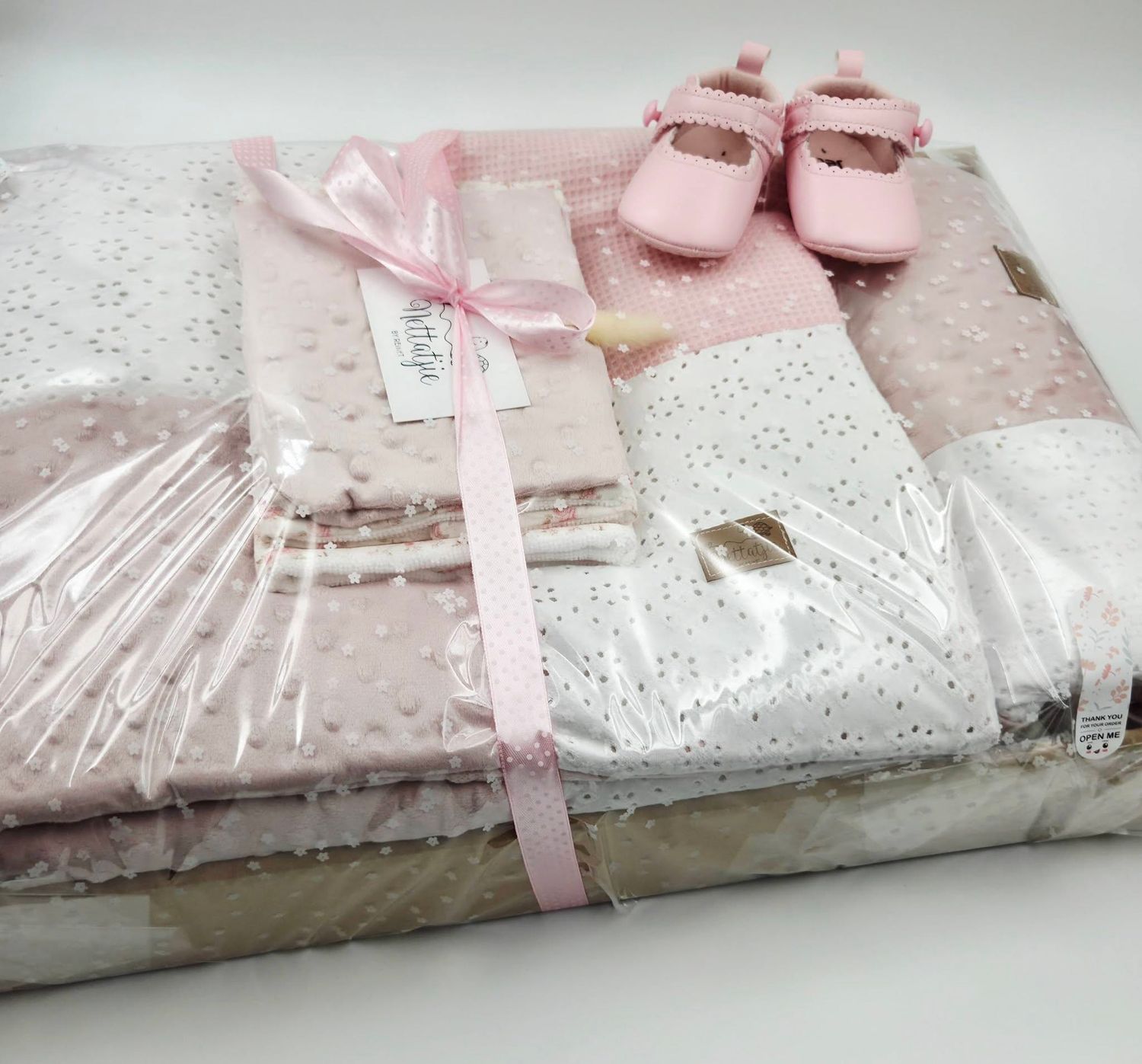 Pink baby girl gift set with sparkle blanket, burp cloths, headband, and Mary Jane shoes in clear packaging.