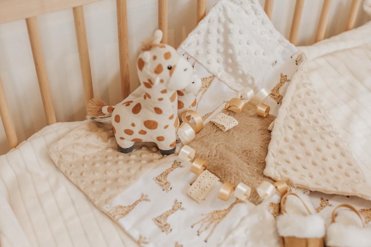 Soft white and beige knitted blankets and textiles arranged in a cozy neutral display with natural lighting.