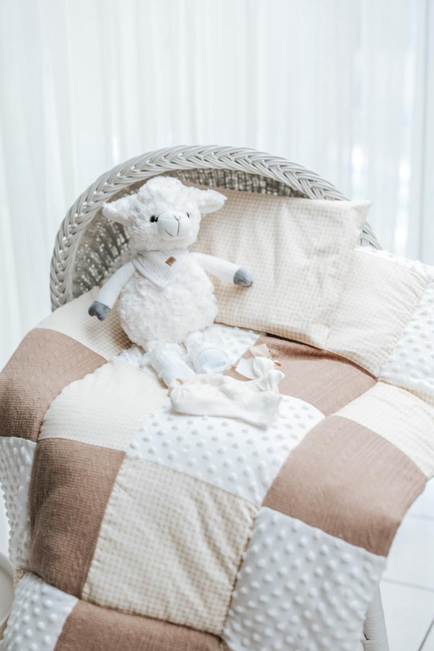 A cozy patchwork baby blanket in neutral beige and white tones with minky fabric and textured squares.