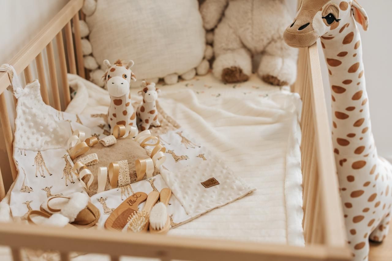 A cozy nursery decorated in neutral tones features a plush giraffe toy and soft bedding in a crib.