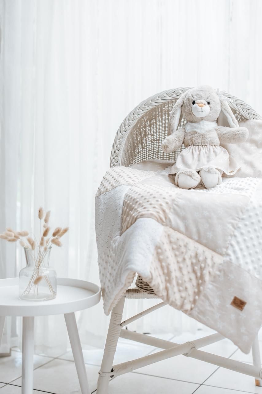 Cozy white nursery decor featuring plush toys and soft textiles arranged on white furniture with natural accents.
