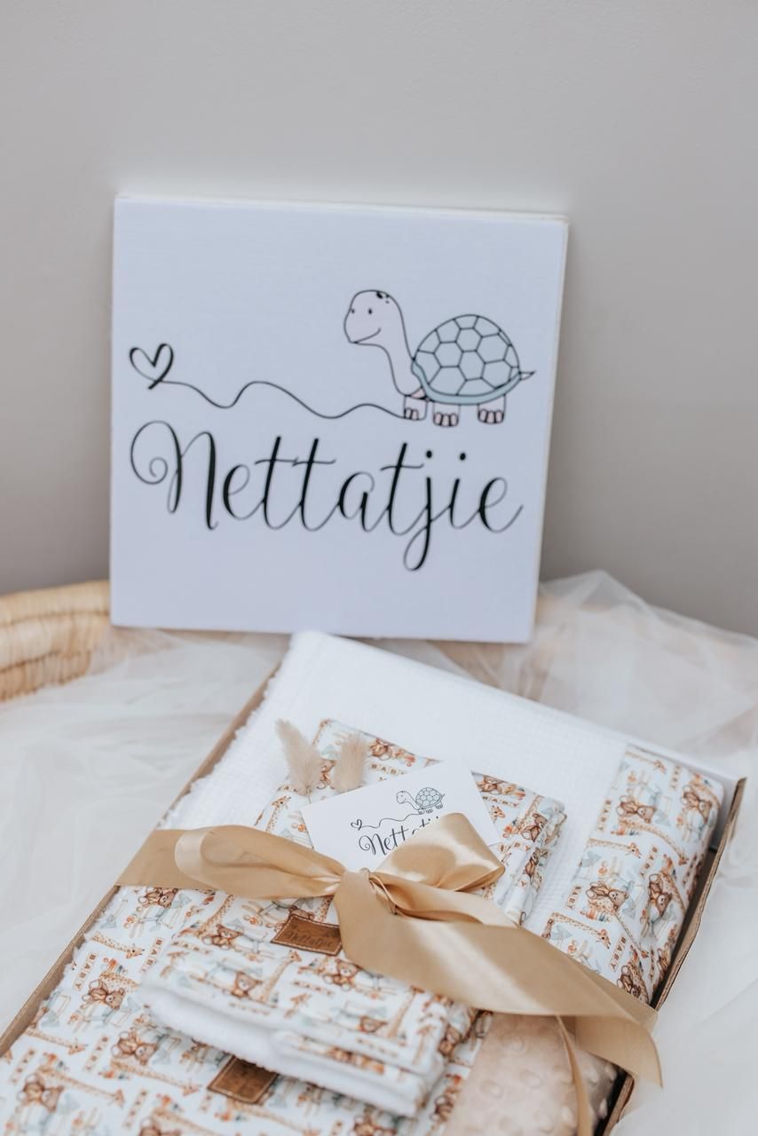White gift box with turtle illustration and 'Nettatje' text above wrapped present.
