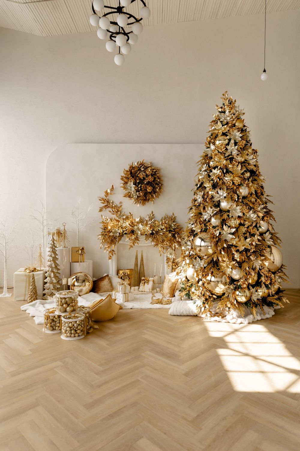 Minimalist holiday decor featuring gold Christmas trees and white accents on herringbone flooring in natural light.