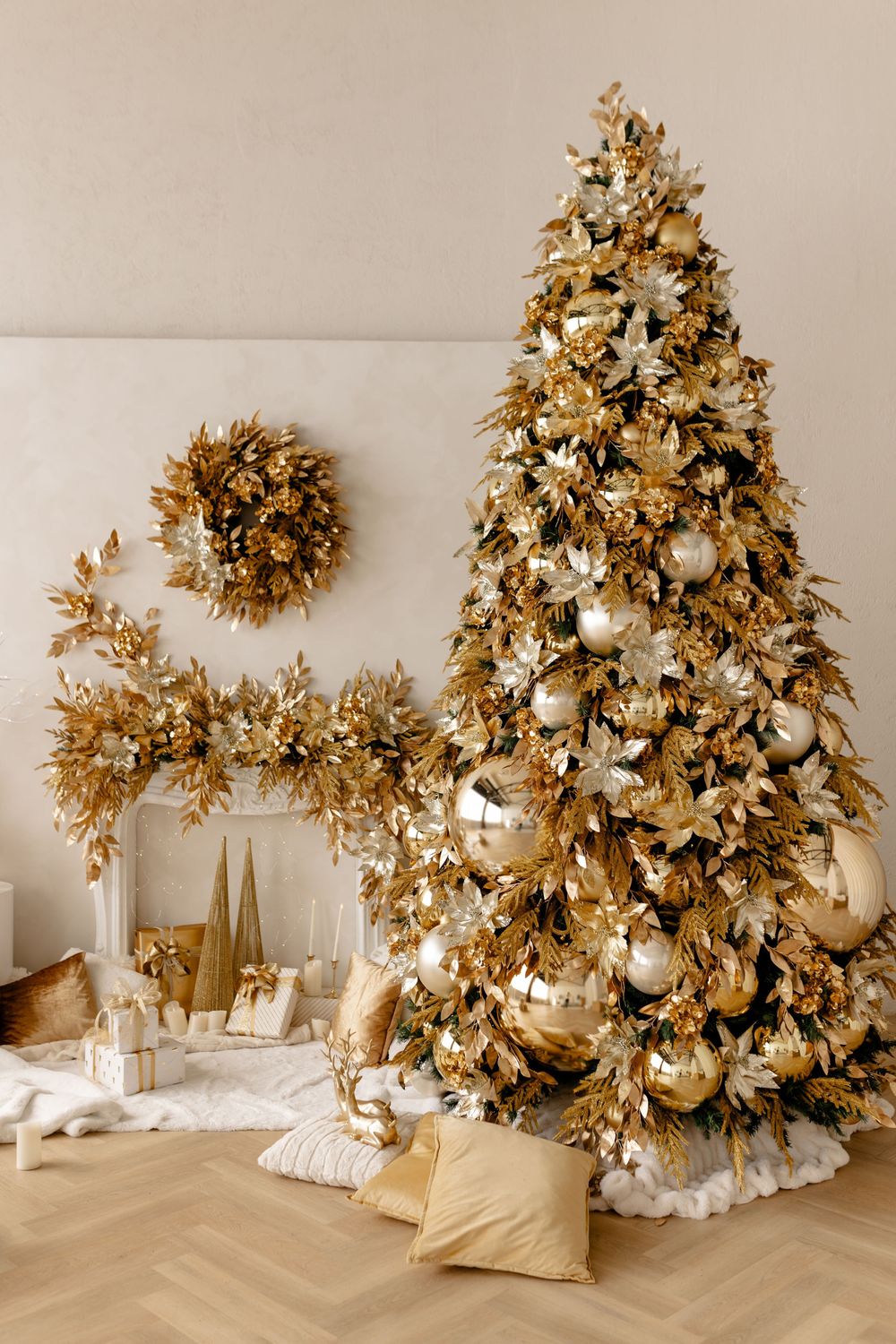 Gold and silver decorated Christmas trees with ornaments and presents arranged in an elegant winter white seating area.