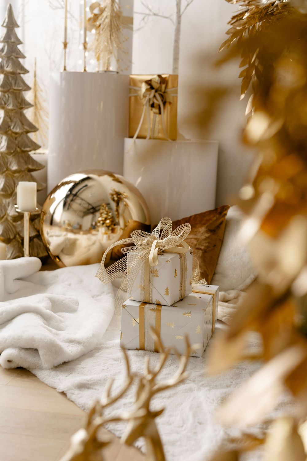 White winter holiday display scene with miniature trees, white snow blanket, and golden warm lighting effects.