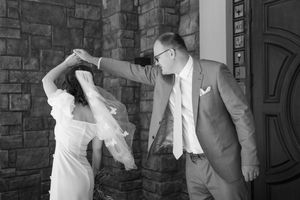 A series of black and white photos showing romantic moments between newlyweds against a brick wall background.