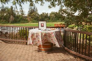 Rustic outdoor venue with wooden railings and scenic greenery for a wedding or special gathering.
