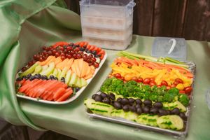 Colorful buffet spread featuring fresh fruit and vegetable platters arranged on serving tables.