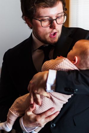 Groom makes silly faces at his baby girl before the ceremony