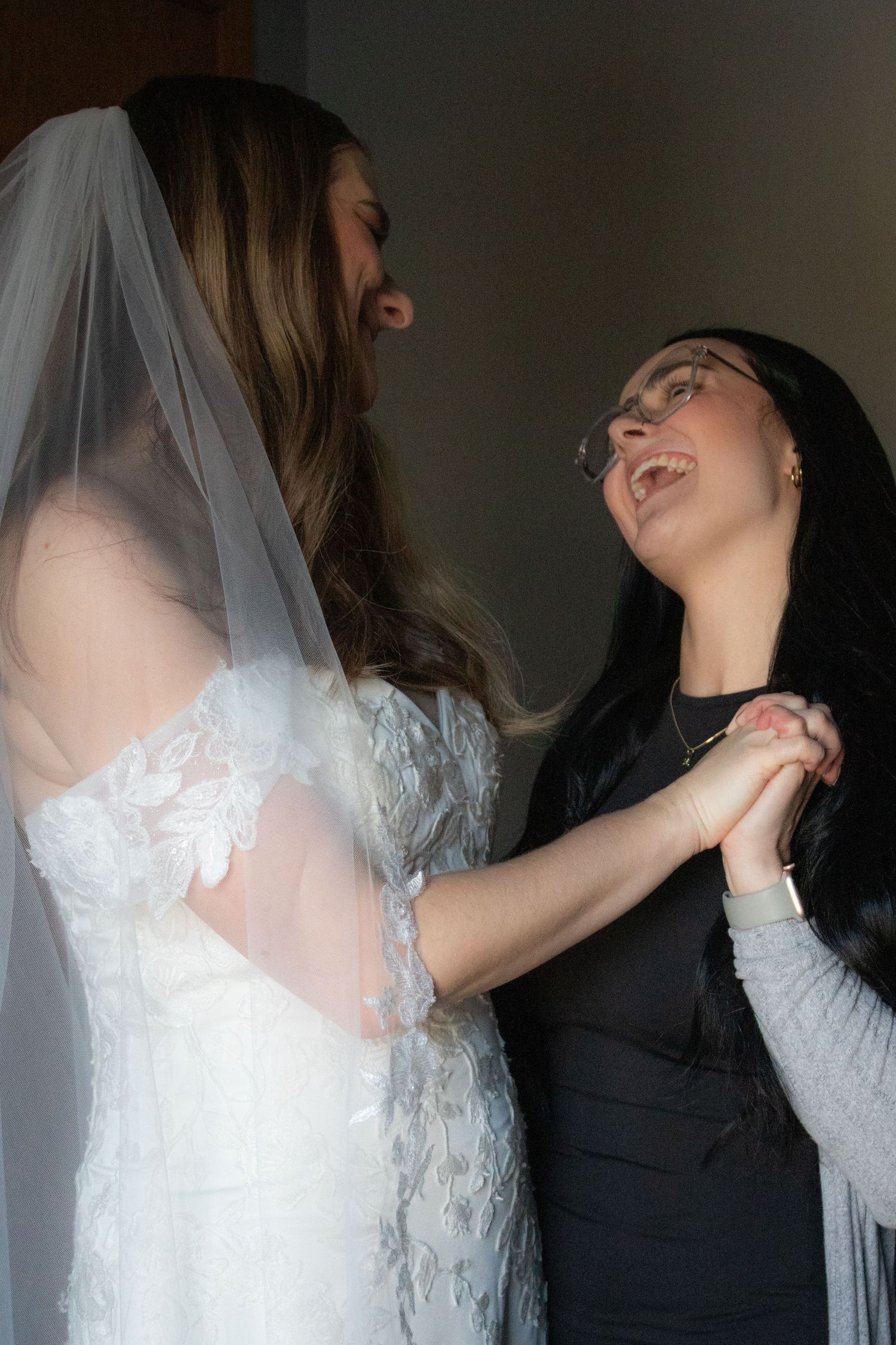 Bride and sister laughing together after wedding ceremony