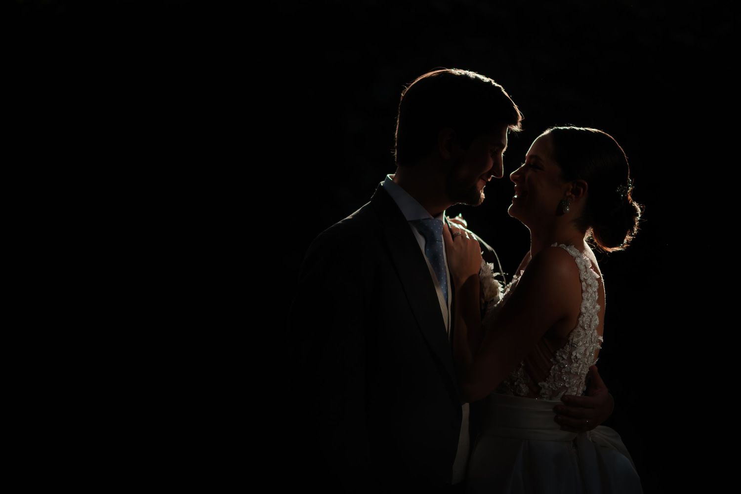 Artistic silhouette portrait with dramatic rim lighting against black background.