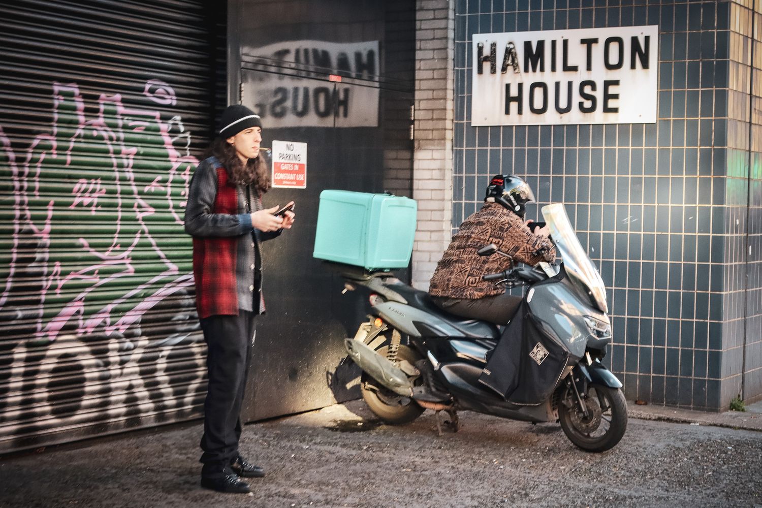 couriers waiting outside hamilton house in london.  candid street portraits by emma drohan