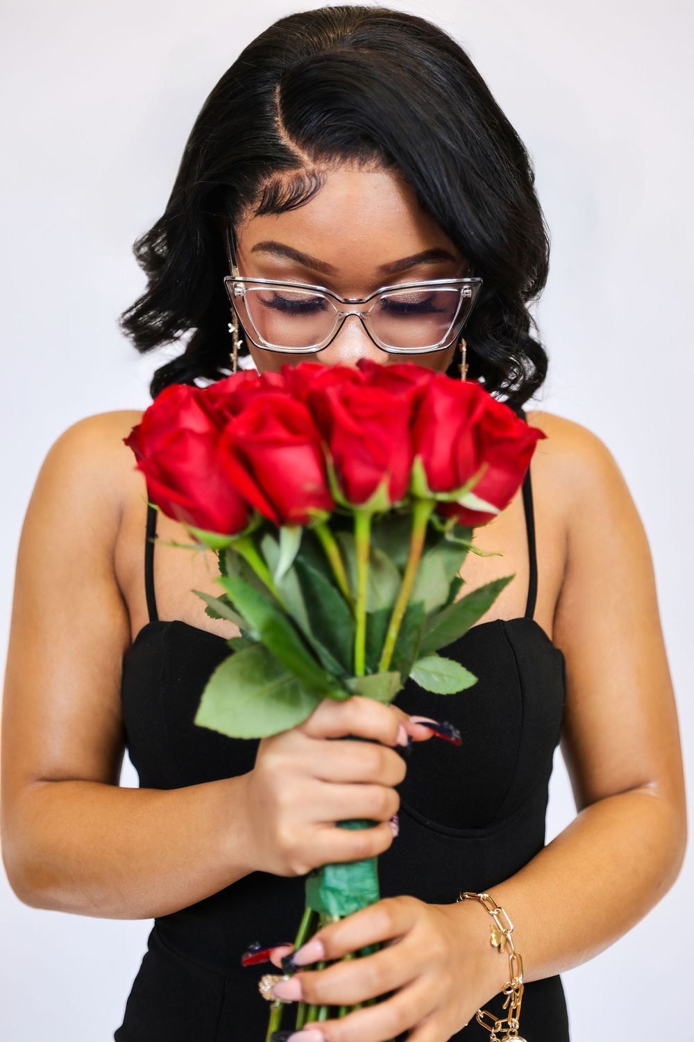 Artistic portrait series with red roses and black outfit against white background.
