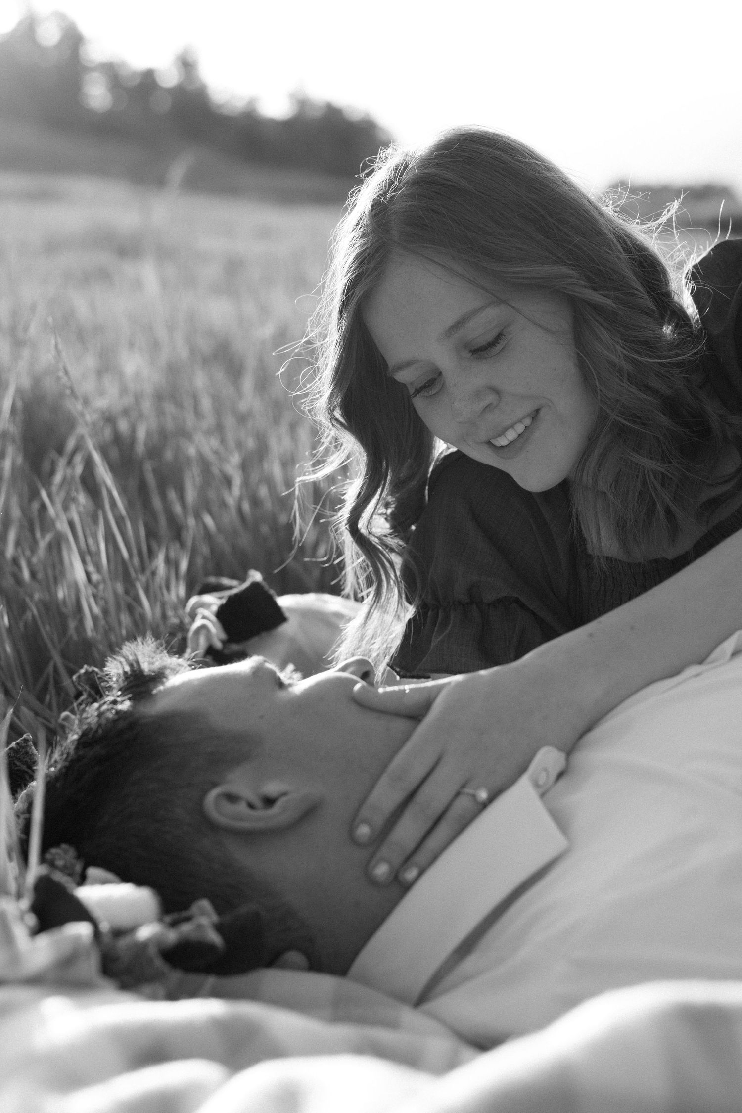 Two people embrace in white outfits while standing on red rock formations in a desert canyon landscape.