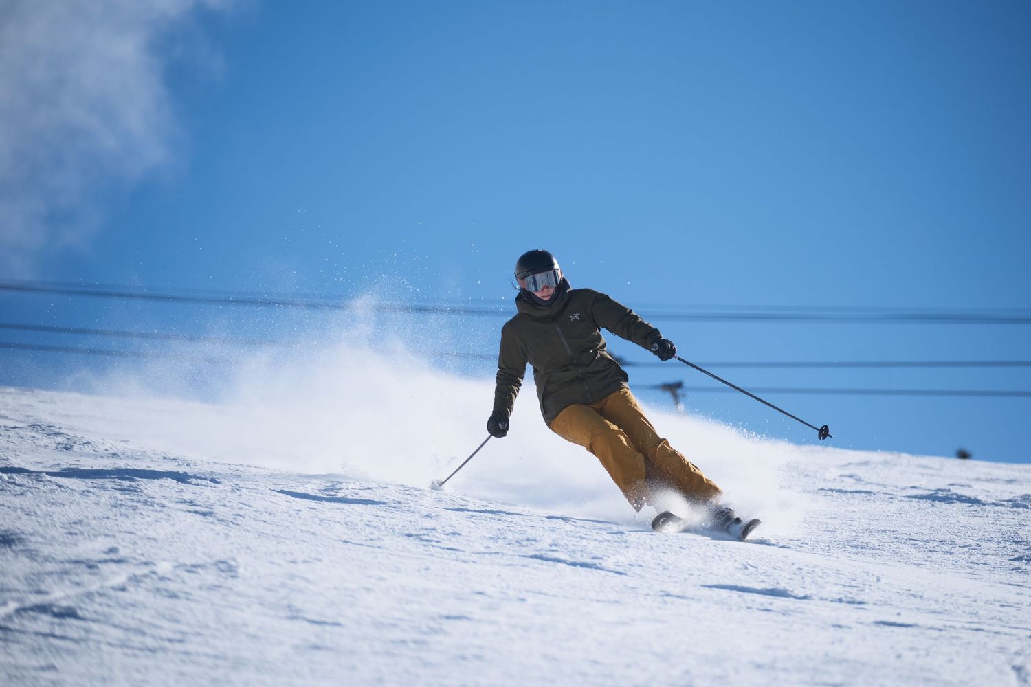 Two skiers in blue jackets chat and laugh together against a snowy mountain backdrop on a bright winter day.
Whistler Blackcomb