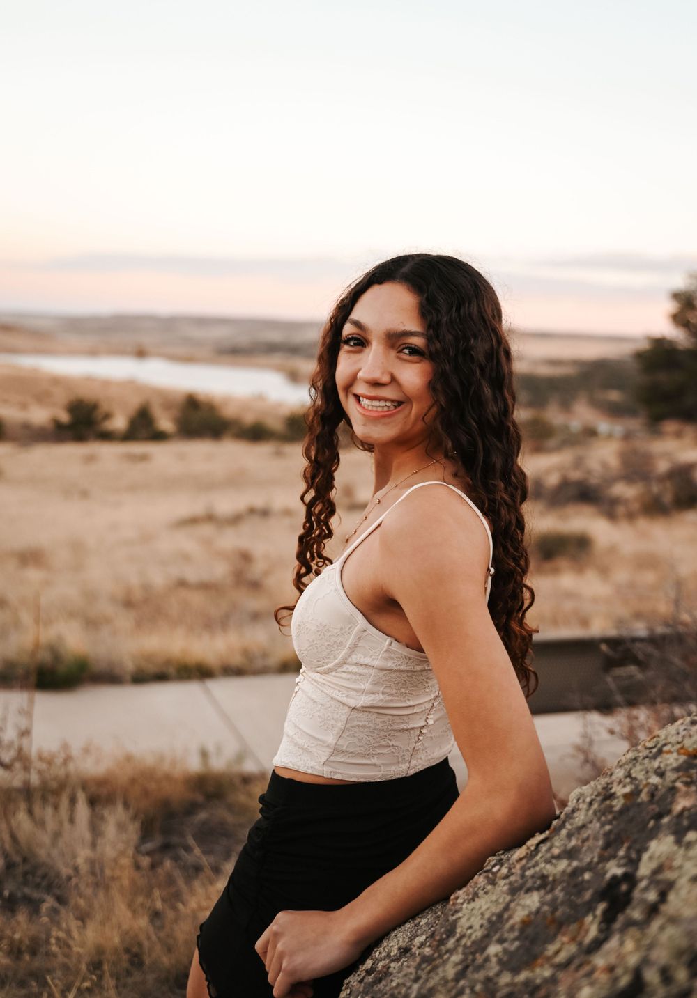 Sunset portrait session on rocky terrain with warm lighting and natural scenery.