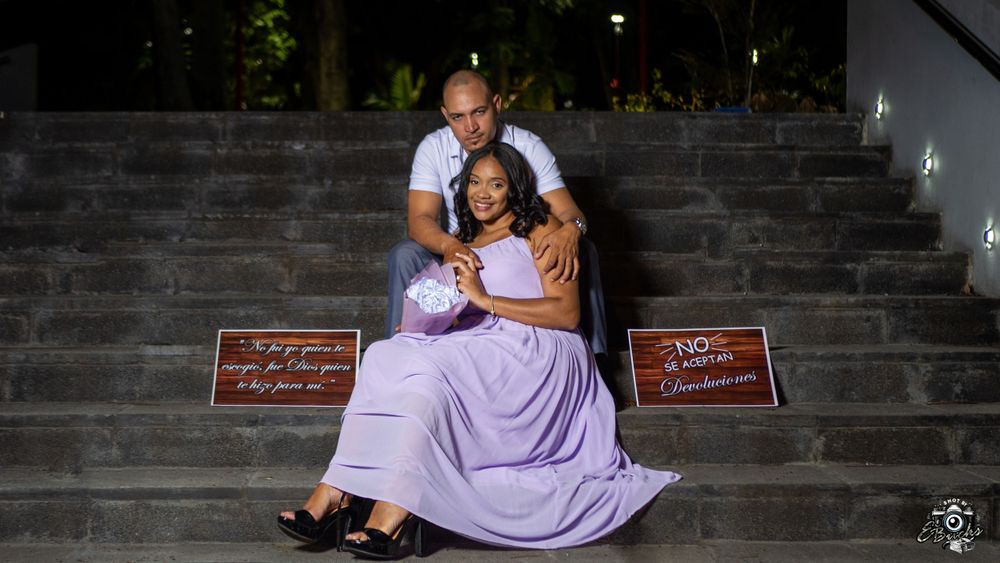Couple sitting romantically on stone steps with decorative signs.