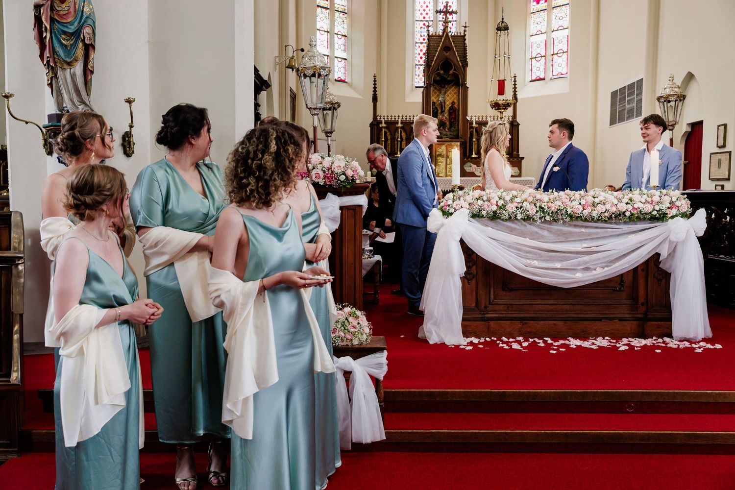 Traditional church wedding ceremony with light blue bridesmaid dresses and classic interior architecture.