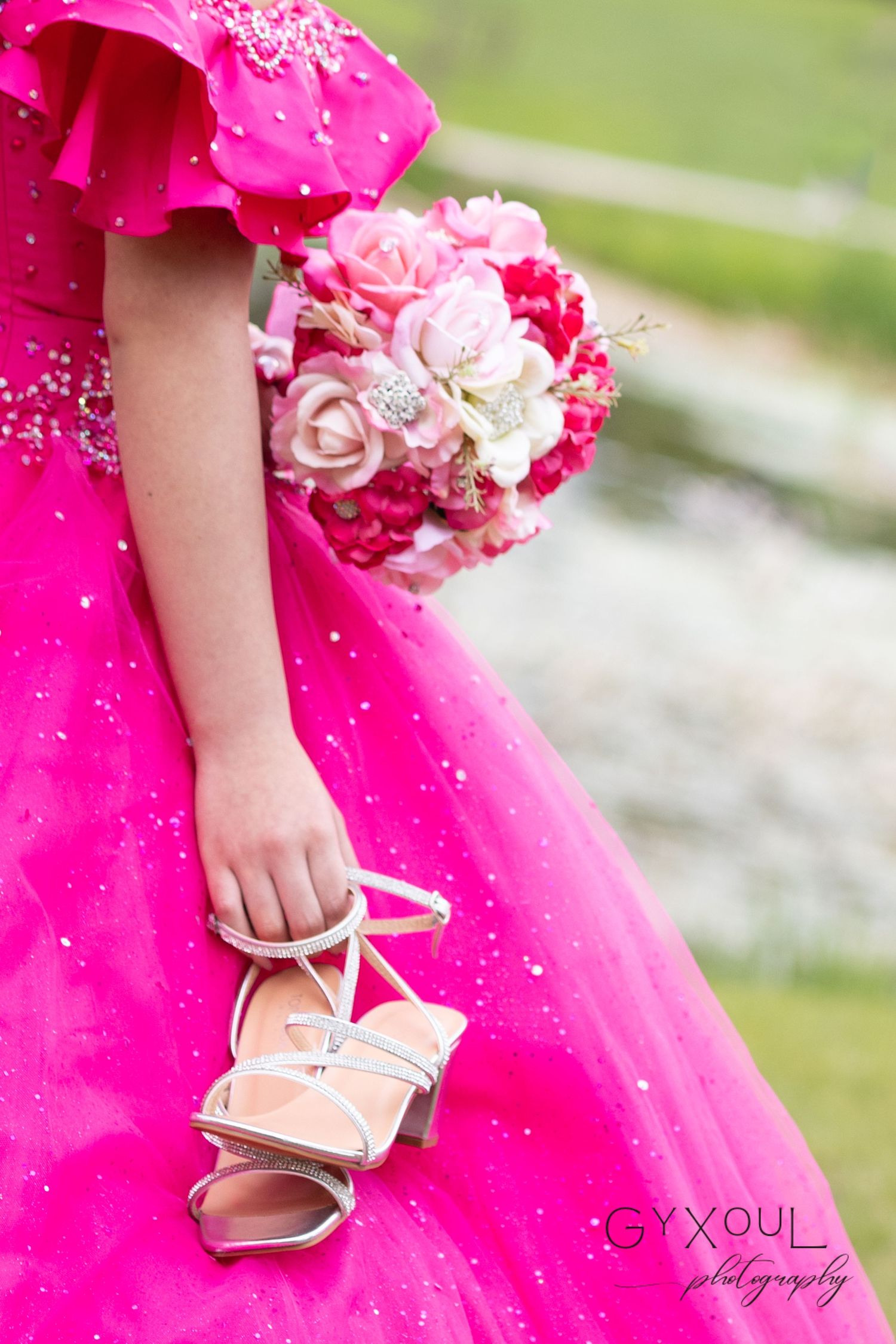 Detail shot of silver strappy sandals and pink rose bouquet against a sparkly pink gown.