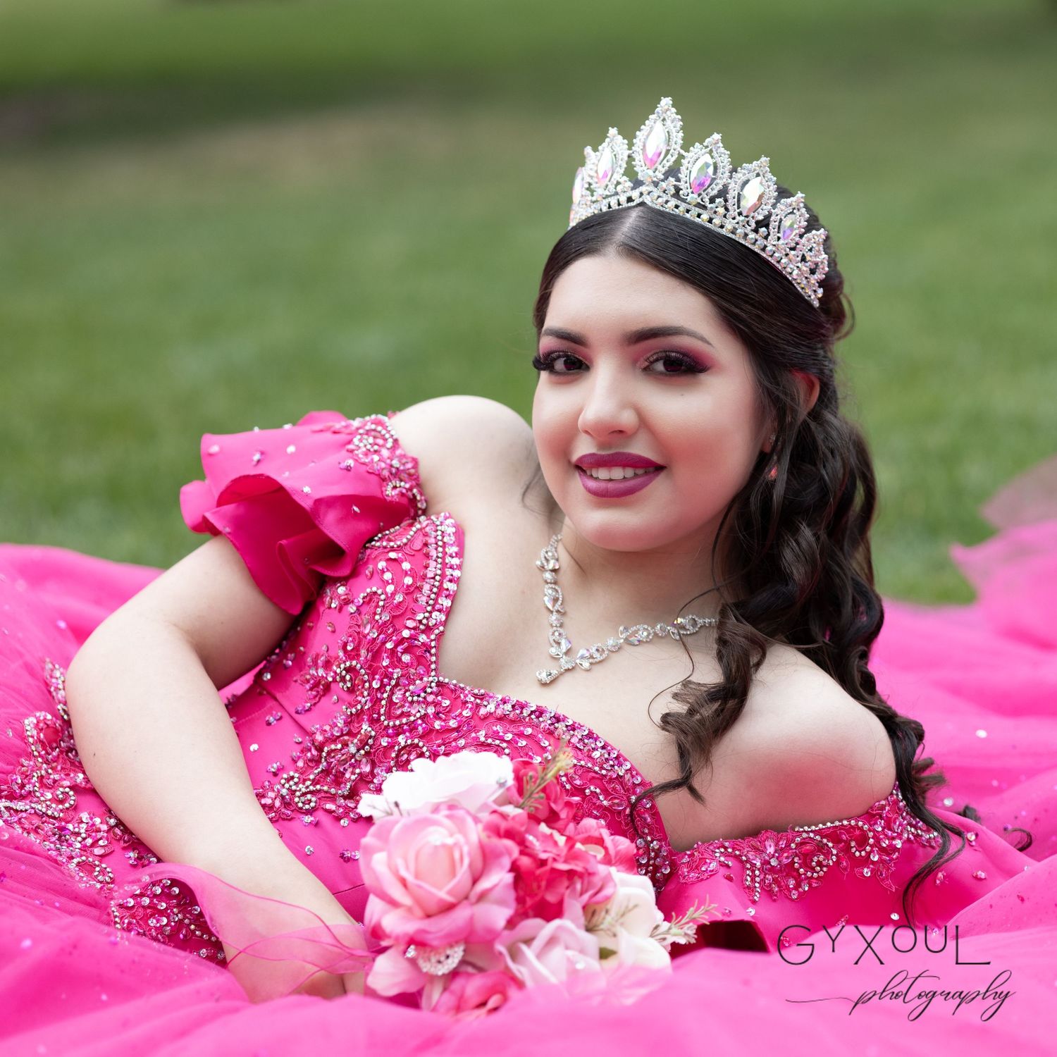 Sparkling tiara and pink gown with crystal embellishments and rose bouquet details.