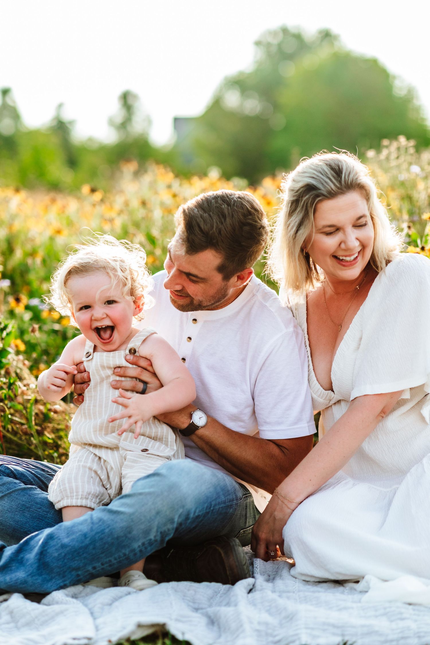 Family having fun during a sunset photoshoot in a wildflower field.