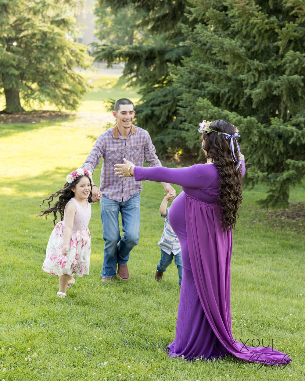 A joyful outdoor family photo session captures playful moments in a park setting.
