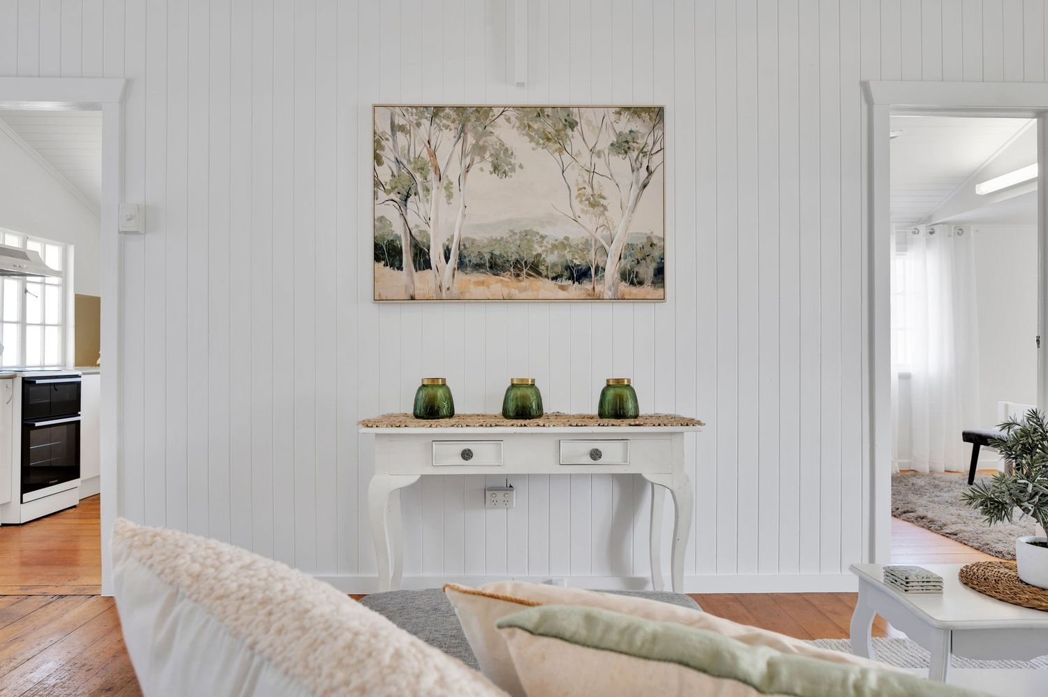 Modern open concept dining area with wooden table and white tile flooring.