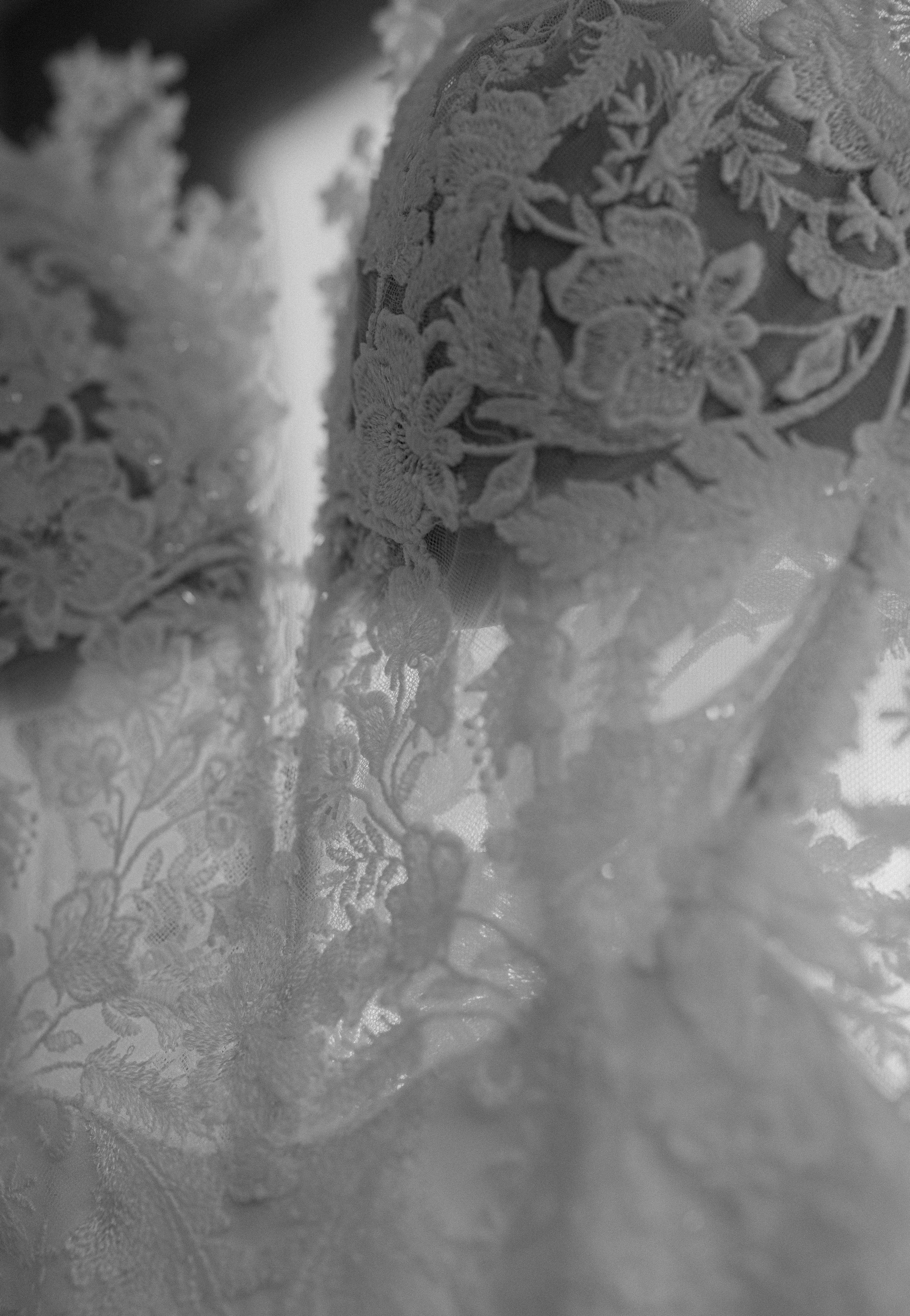 Detailed close-up of intricate lace patterns on wedding dress fabric.
