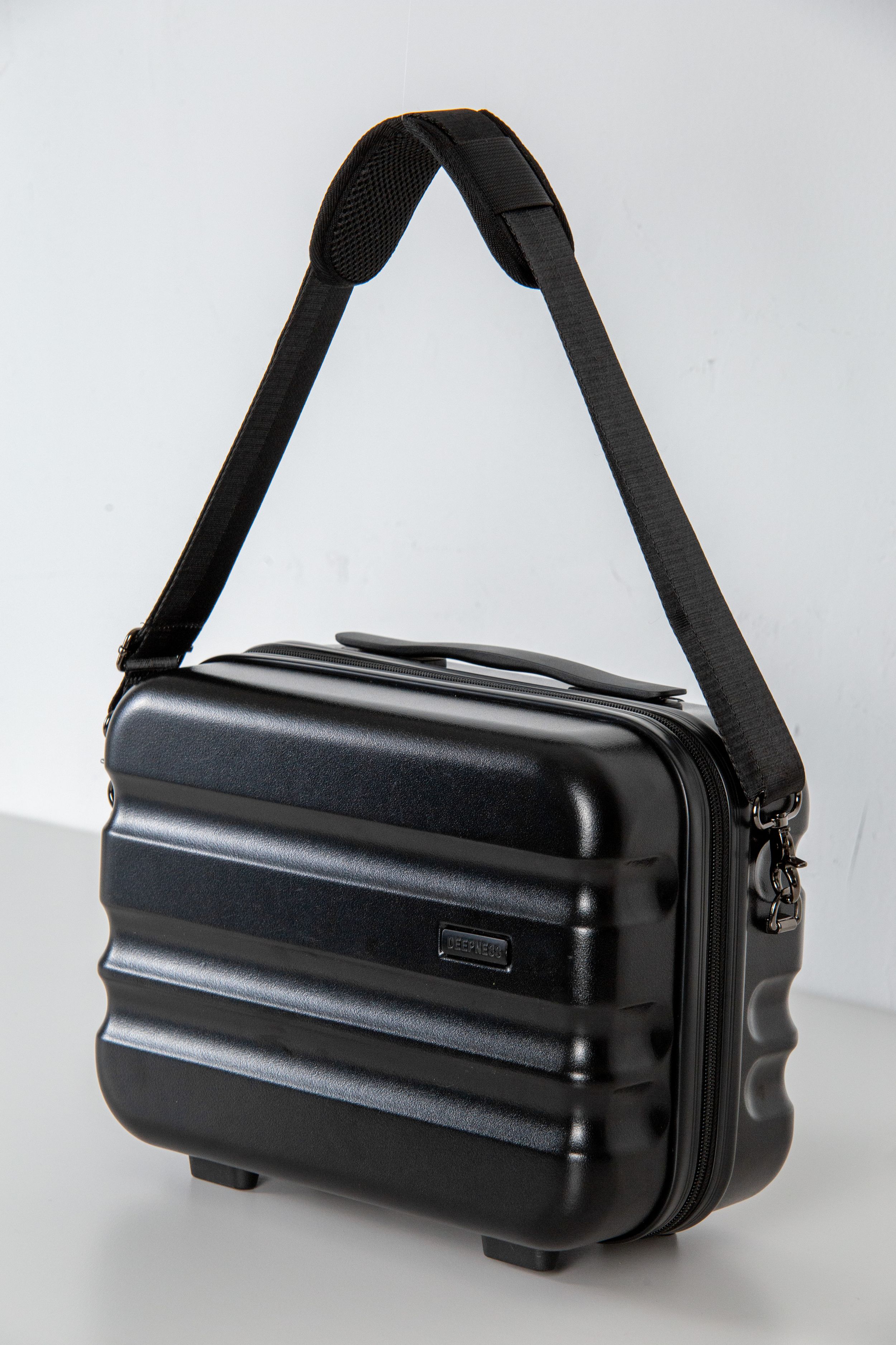 Black hard-shell messenger bag with shoulder strap displayed against white background.