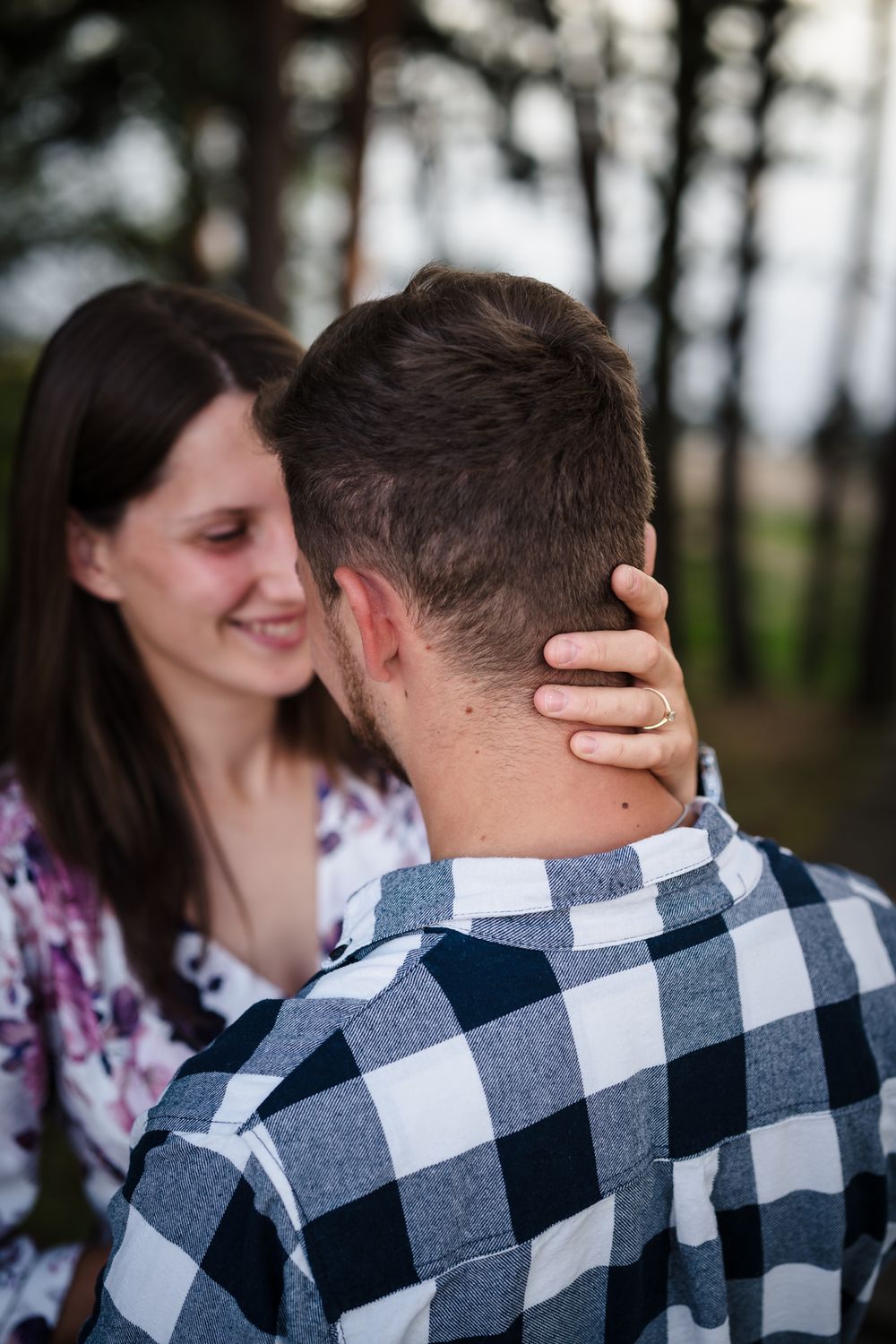 Intimate moment captured between two people wearing casual attire outdoors.