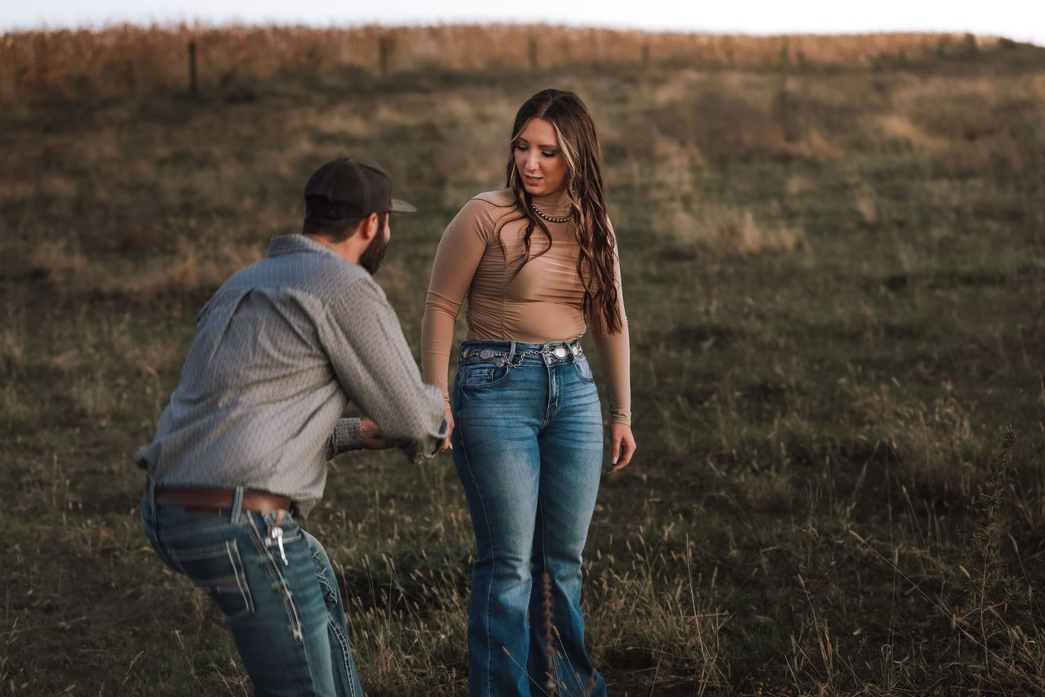Couple sharing a romantic moment in a golden field at sunset.
