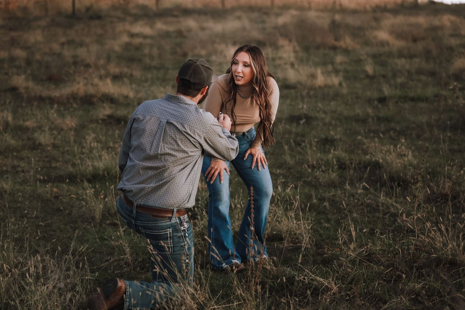 Candid engagement moment captured in a rustic field setting.