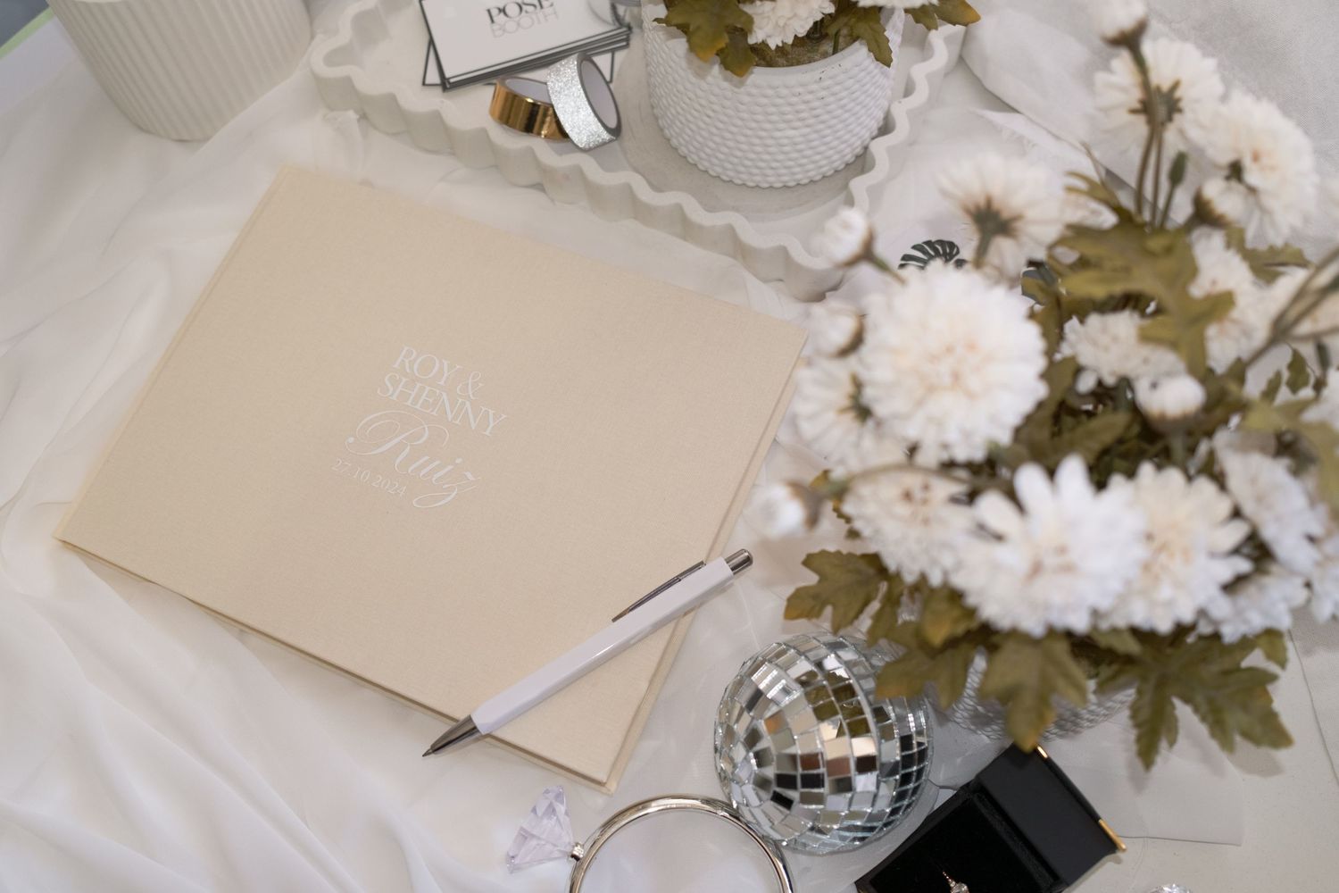 Elegant guest book setup with white flowers and silver disco ball decorations. Perth WA Photo booth Hire Event Booth