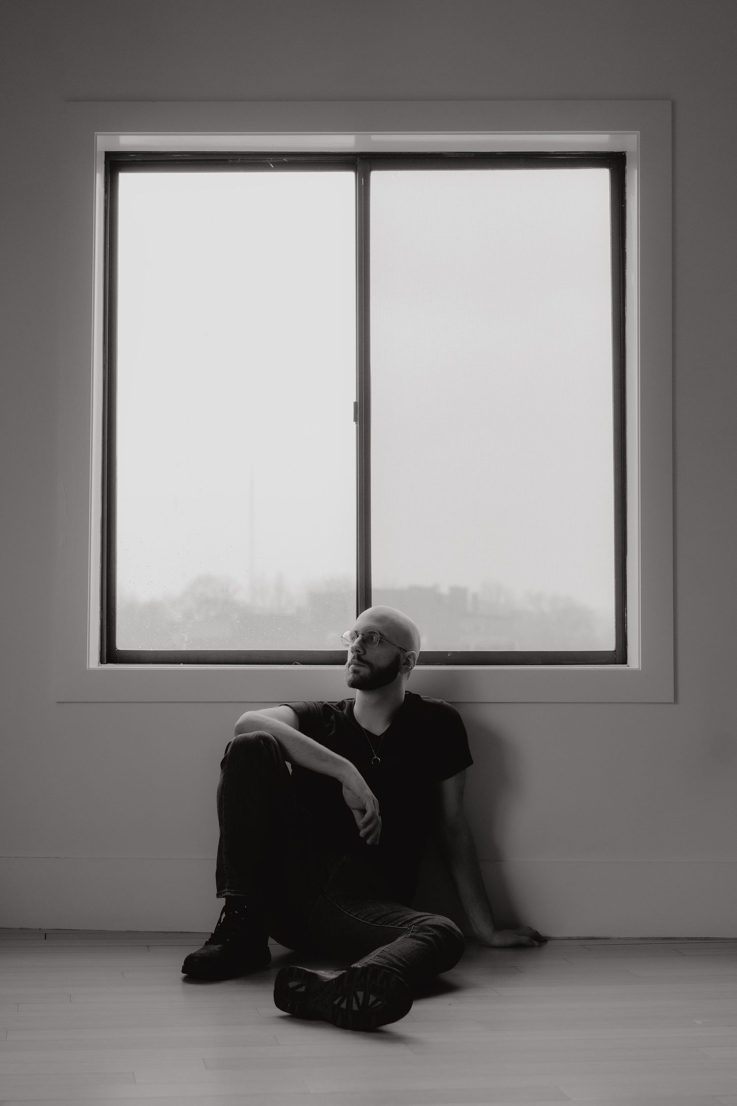 A black and white photo of Michael sitting under the window