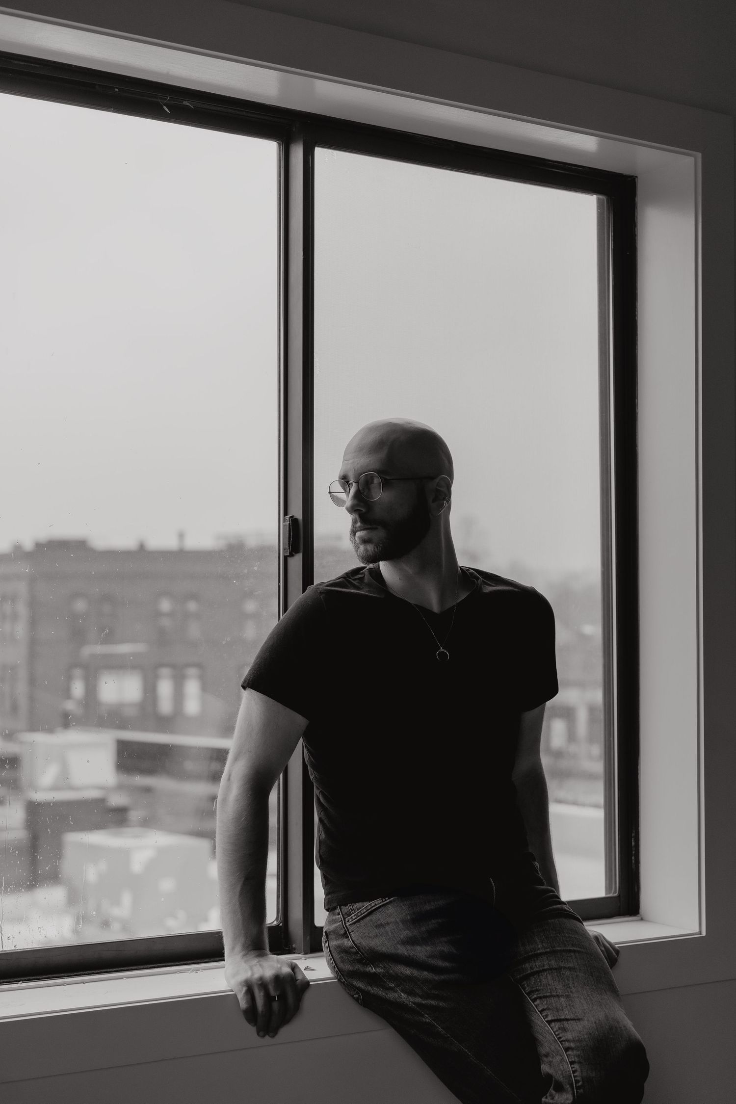Black and white photo of Michael sitting on the window sill